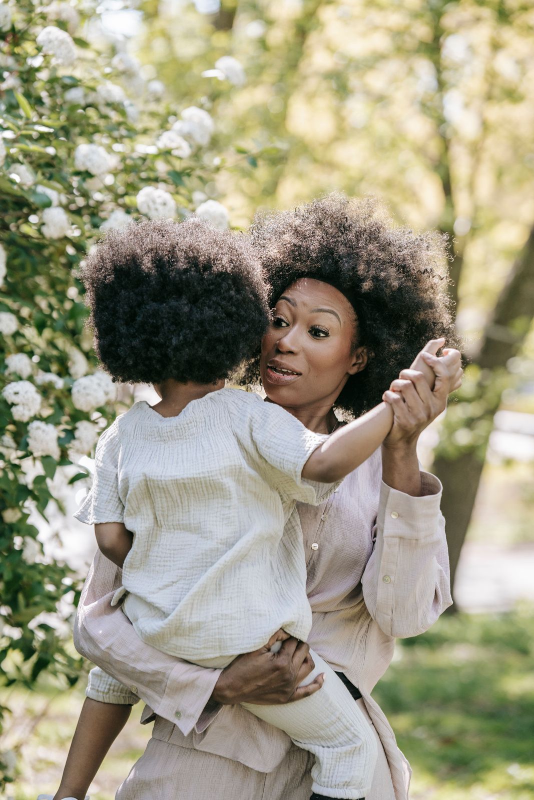 A mum holding her young child in a garden